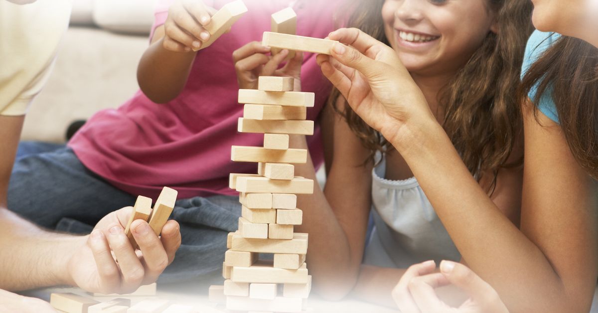 Família reunida jogando jogando jenga com escolhas e diversão em grupo